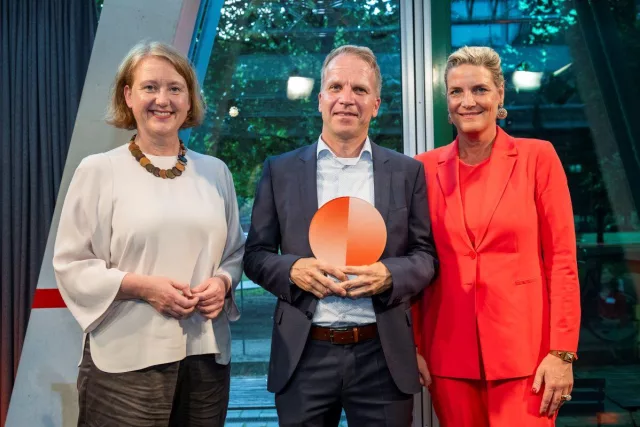 Thorsten Kolwe nimmt den Preis von Bundesministerin Lisa Paus und Evelyn De Gruyter entgegen