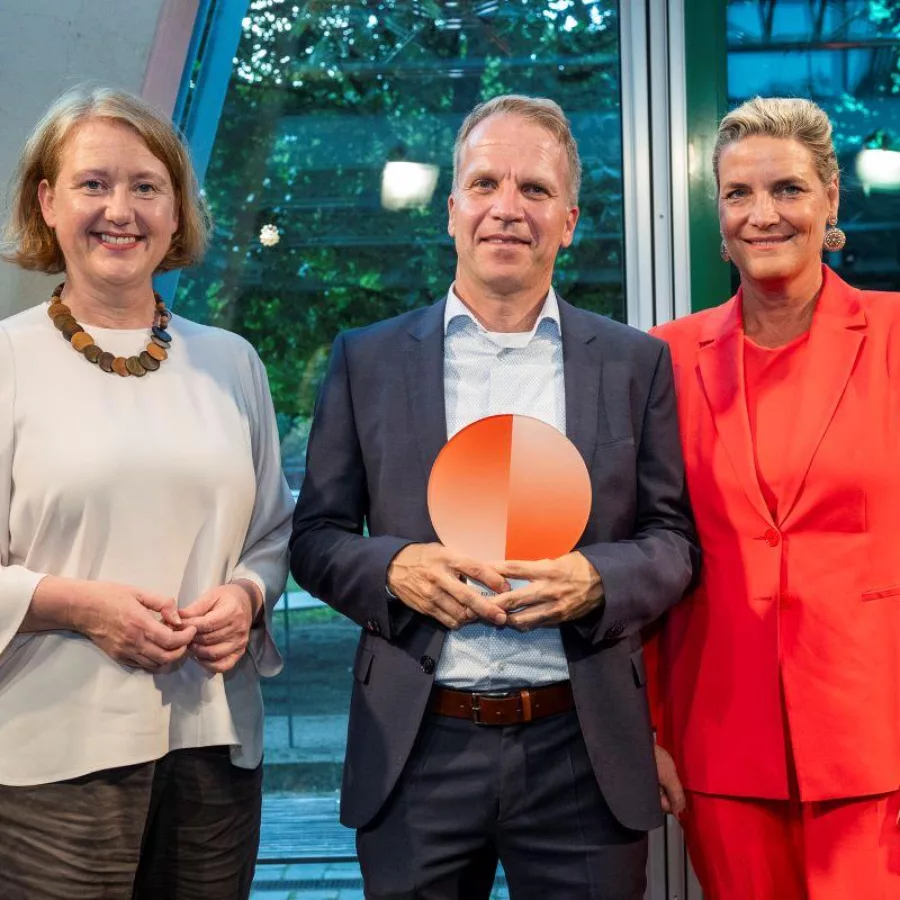 Thorsten Kolwe nimmt den Preis von Bundesministerin Lisa Paus und Evelyn De Gruyter entgegen