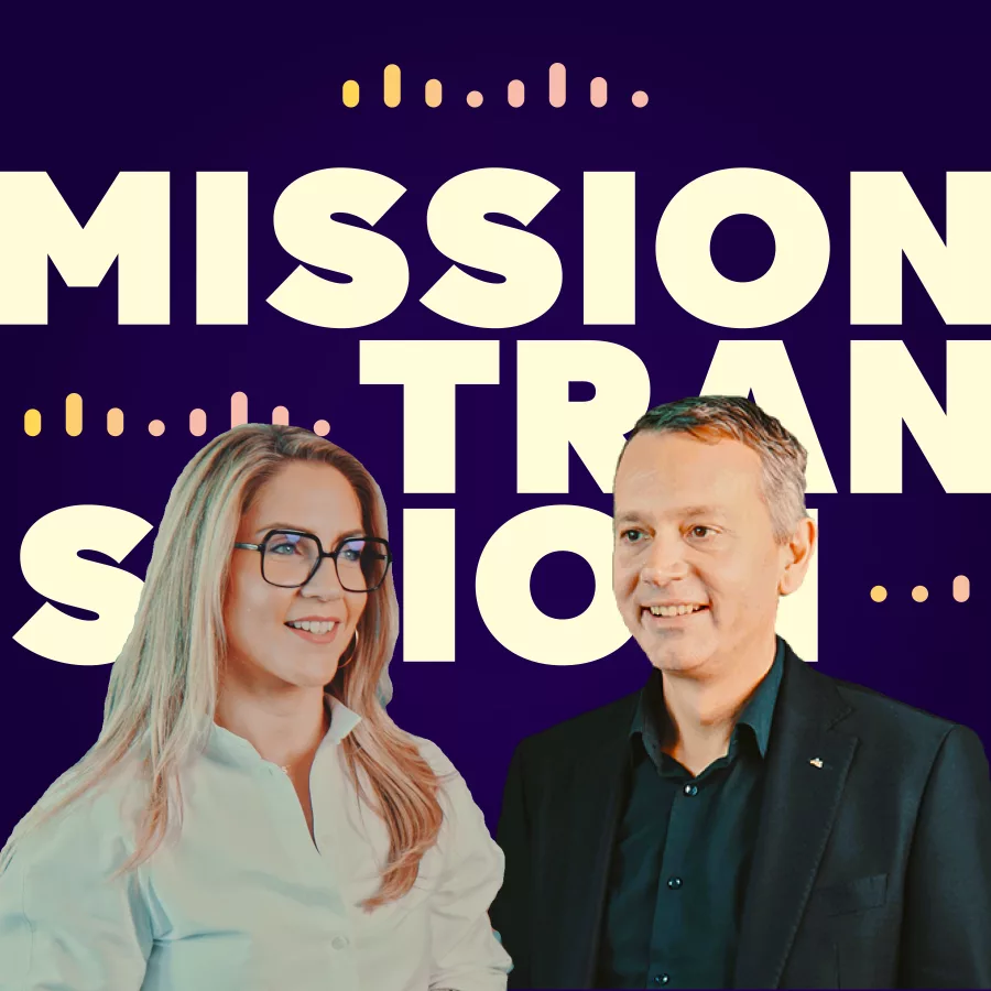 Vor einem dunkelblauen Hintergrund stehen eine Frau und ein Mann nebeneinander, beide in Business-Outfits. Hinter ihnen ist groß der Schriftzug „MISSION TRANSITION“ zu sehen, unterbrochen von grafischen Designelementen in Pastellfarben. Die Szene vermittelt einen professionellen und dynamischen Eindruck.