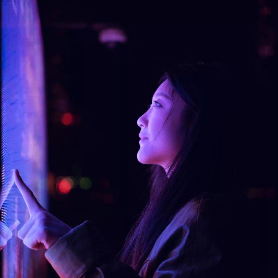 Entdecken Sie die faszinierende Welt der interaktiven Technologie! Dieses Bild zeigt eine Person, die einen hochmodernen Touchscreen in einer dunklen, stimmungsvollen Umgebung bedient. Die leuchtenden Farben und das futuristische Design machen es zu einem perfekten Beispiel für die Verschmelzung von Mensch und Technologie.